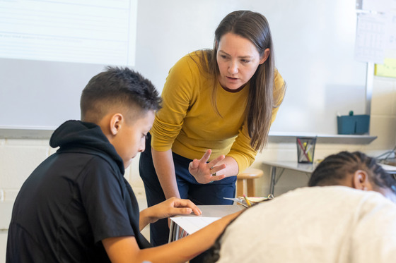 A teacher helps a student complete work