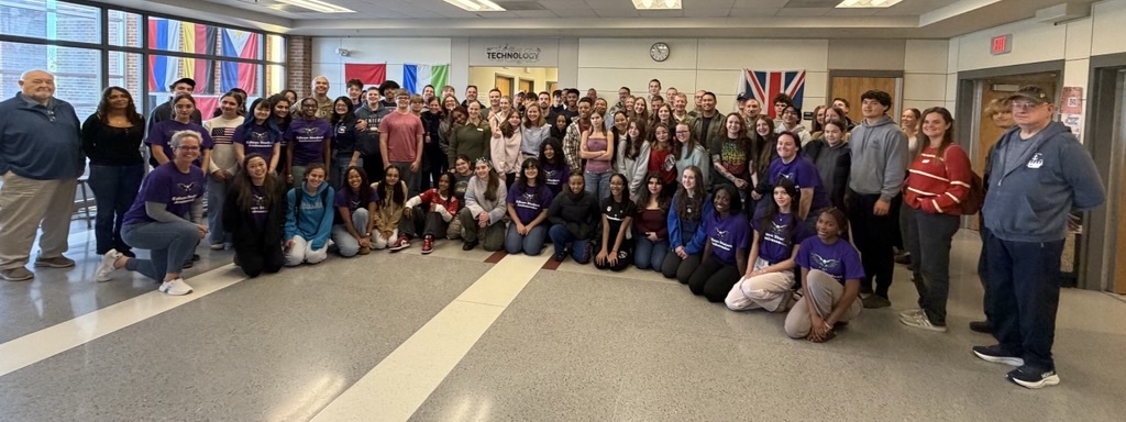 adults and students standing in a hallway for a photo