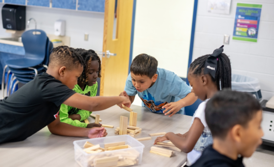 students playing a block game together on a cafeteria table