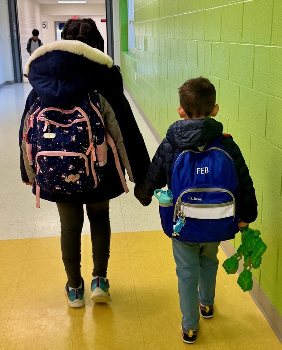 two students walking in the hallway holding hands