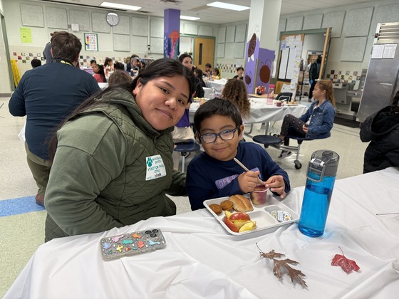 A parent joins her son for Thanksgiving Luncheon