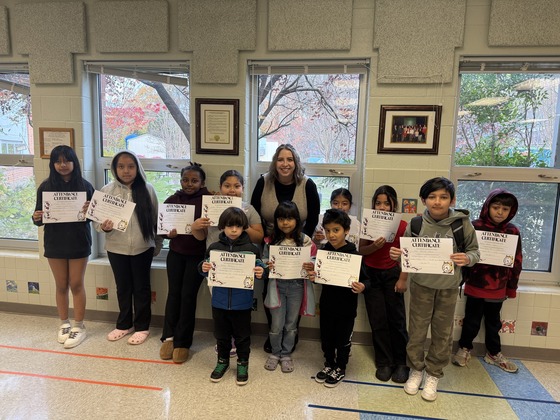 Students gather together holding up a certificate 