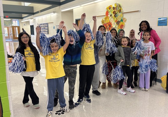 Mrs. Opie with Student Ambassadors holding pom-poms