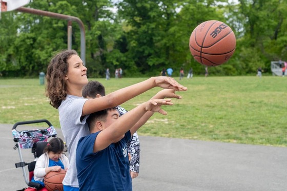students playing basketball together