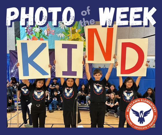 Photo of the Week: students holding large posters that spell out KIND