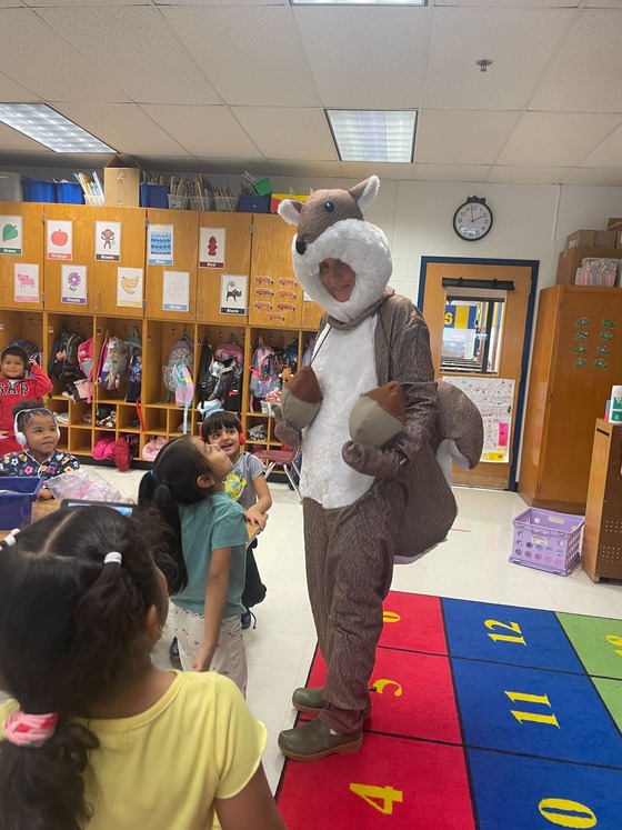 A person in a squirrel costume visiting a classroom of young children