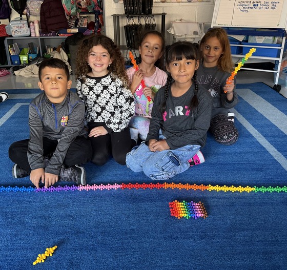 Students sit on the carpet in a classroom 