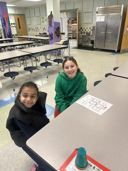 An older and younger student do a get to know you activity 