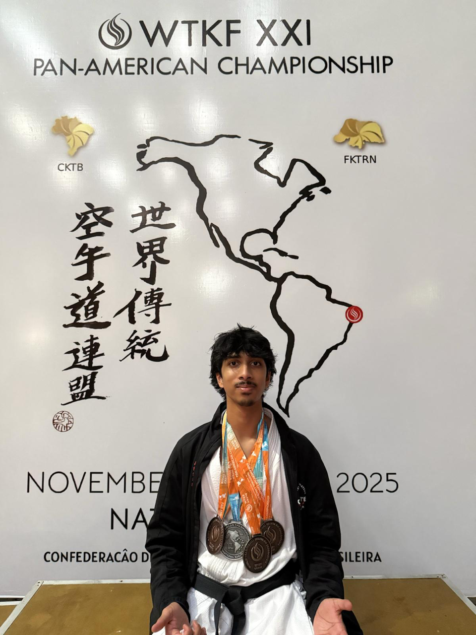 A student poses with four medals at the pan American Karate Championship