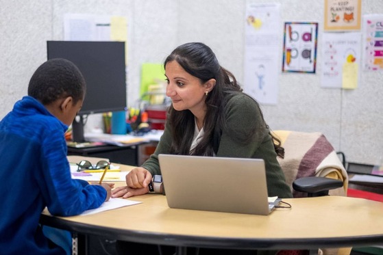 teacher works with a student from across a table