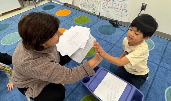 A teacher and student giving each other a high five