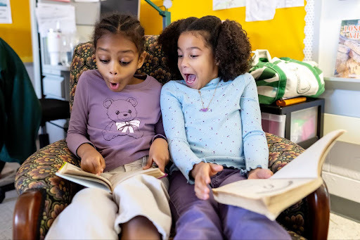 two students read a book together