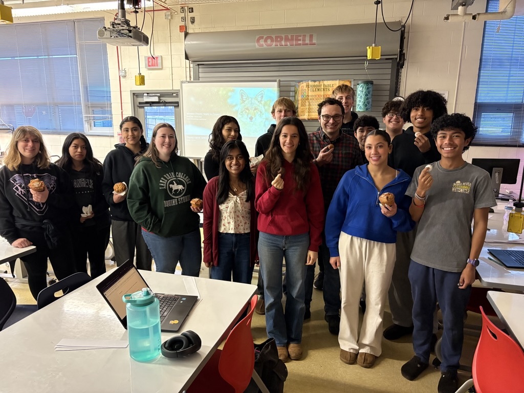 students standing in a classroom holding treats