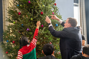 Senator Warner decorates the tree with some Woodburn Students 