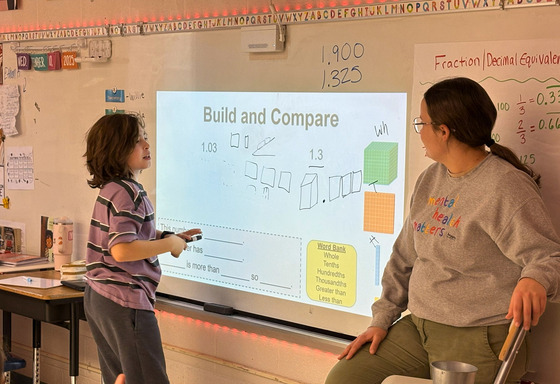 student explaining his math problem on whiteboard 