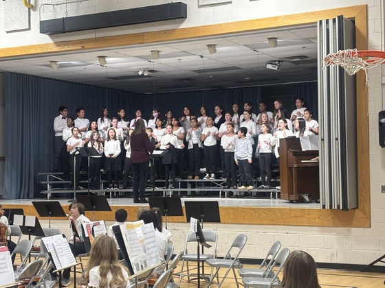 5th and 6th grade students stand on stage for the chorus concert 
