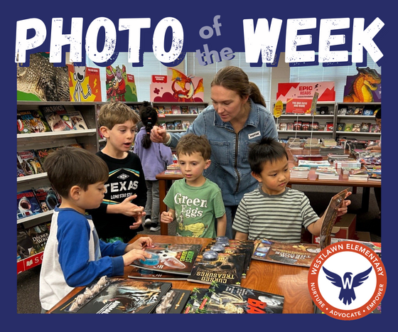 A volunteers helps students find books at the book fair