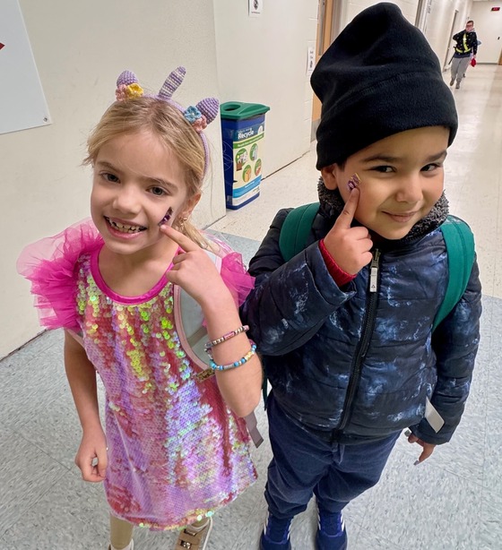 Two smiling students in the hallway