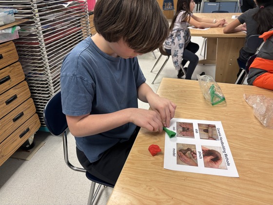 A student focuses on his clay project 