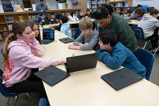 students work together on a laptop