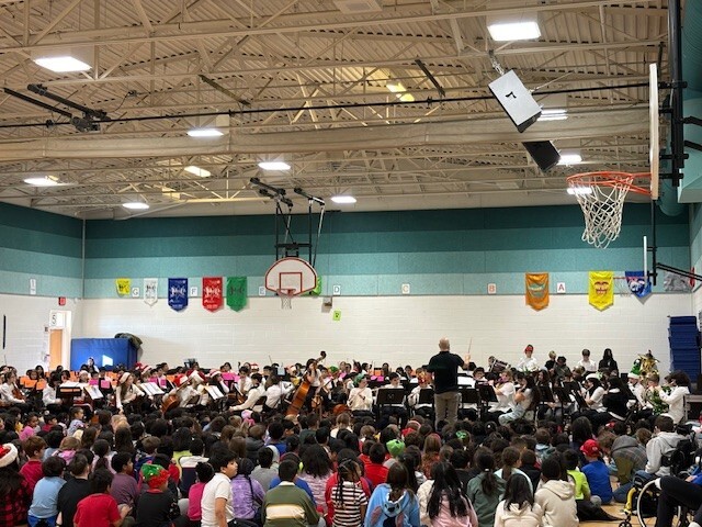 band and strings students sitting in the gym for their winter concert