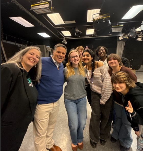 Adults and high school students standing together