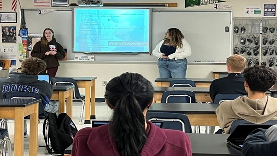 College students speaking to seated high school students