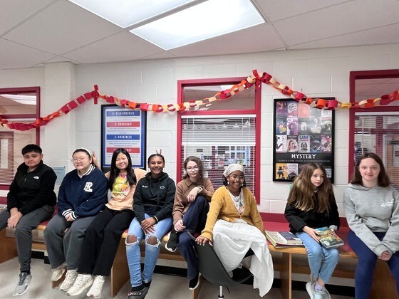 Students sitting on counter beneath paper chain