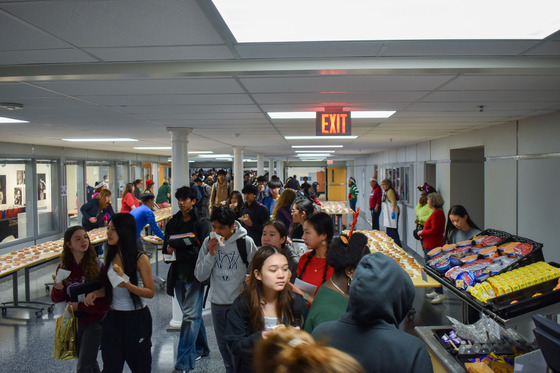 Students at the tables as they walk through commons picking up their Krispy Kreme donut