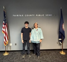 Student Representative and School Board Member standing between two flags