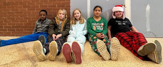 Students in pajamas sitting in the hallway