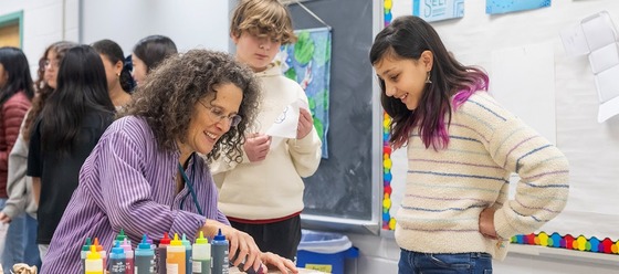 students watching an artist use paints in a demonstration