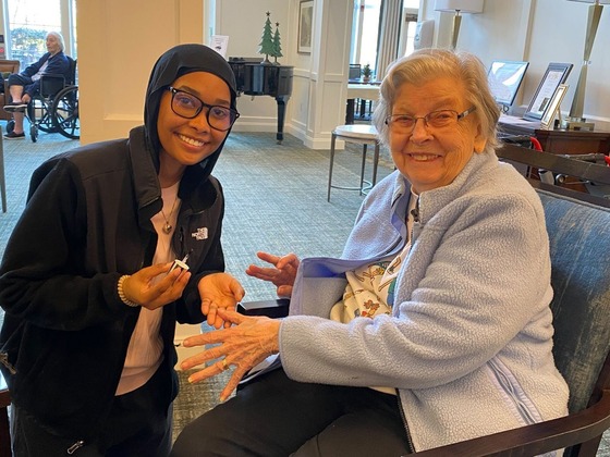 student paints the nails of a senior