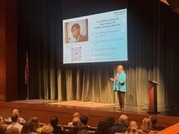 Dr. Reid speaks on stage to an audience
