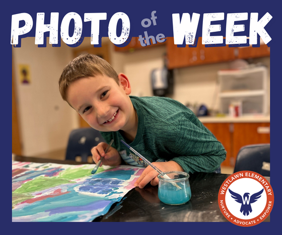 Photo of the Week: a student smiles while working on a watercolor painting