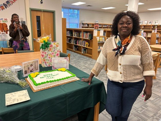 Ms. Yaa poses with her retirement cake 