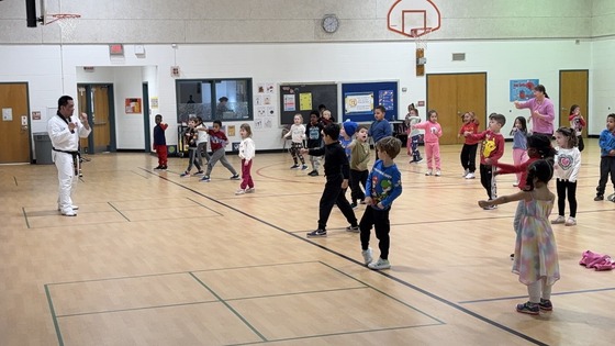 Students practicing martial arts punches under the direction of an instructor