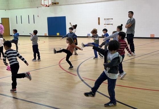 Students practicing kicks under the direction of an instructor