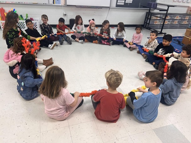 Mrs. Shumaker and a class of students use the new extra large stretchy band.