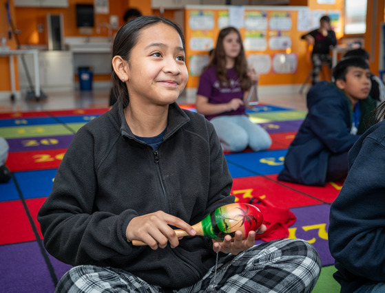 Student with maraca in music class