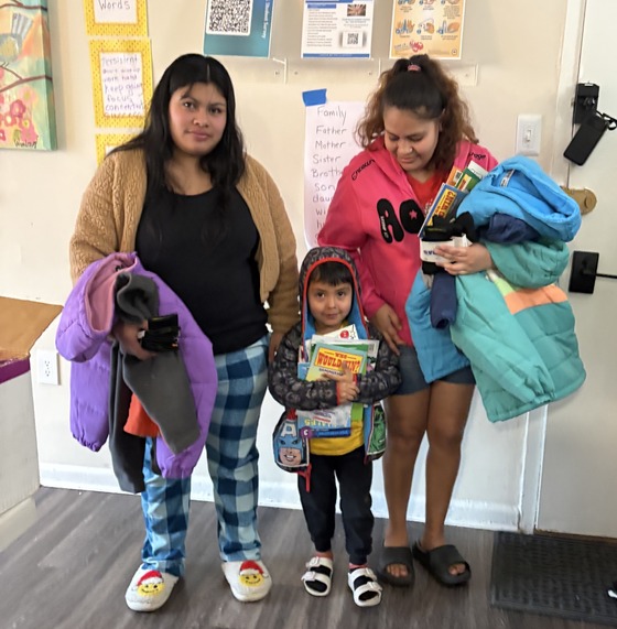 A family stands with coats in their hands 