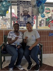 Ms. Brown and Ms. Diggs sitting on a bench smiling