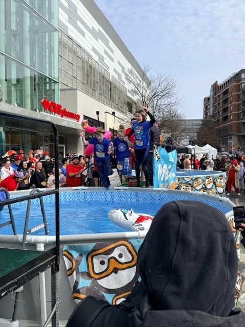 three students jumping into a pool at the Polar Plunge