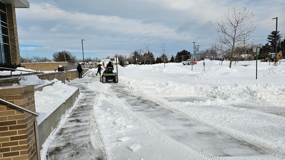 Custodial staff hard at work outside Rocky Run clearing sidewalks for students
