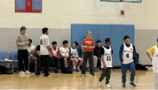 students playing basketball with coaches on the sideline