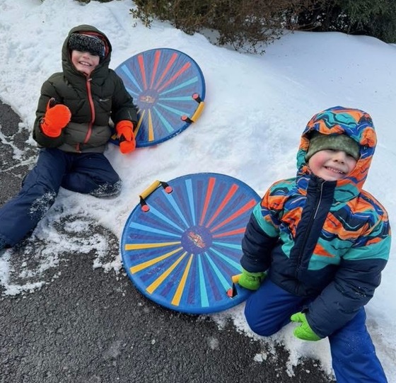 Two students smile in the snow 