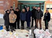 Dr. Reid smiles outside of a school with staff
