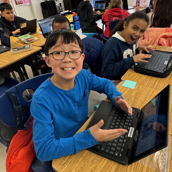 Two students excited while working on their laptops
