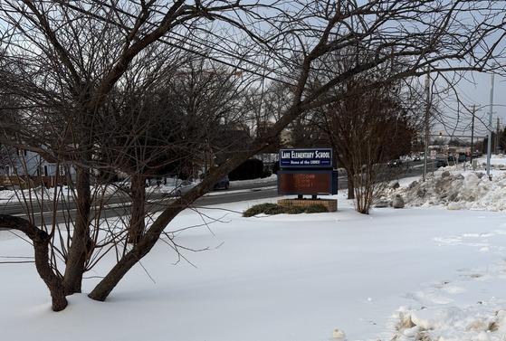 Lane electronic "Welcome" sign surrounded by snow