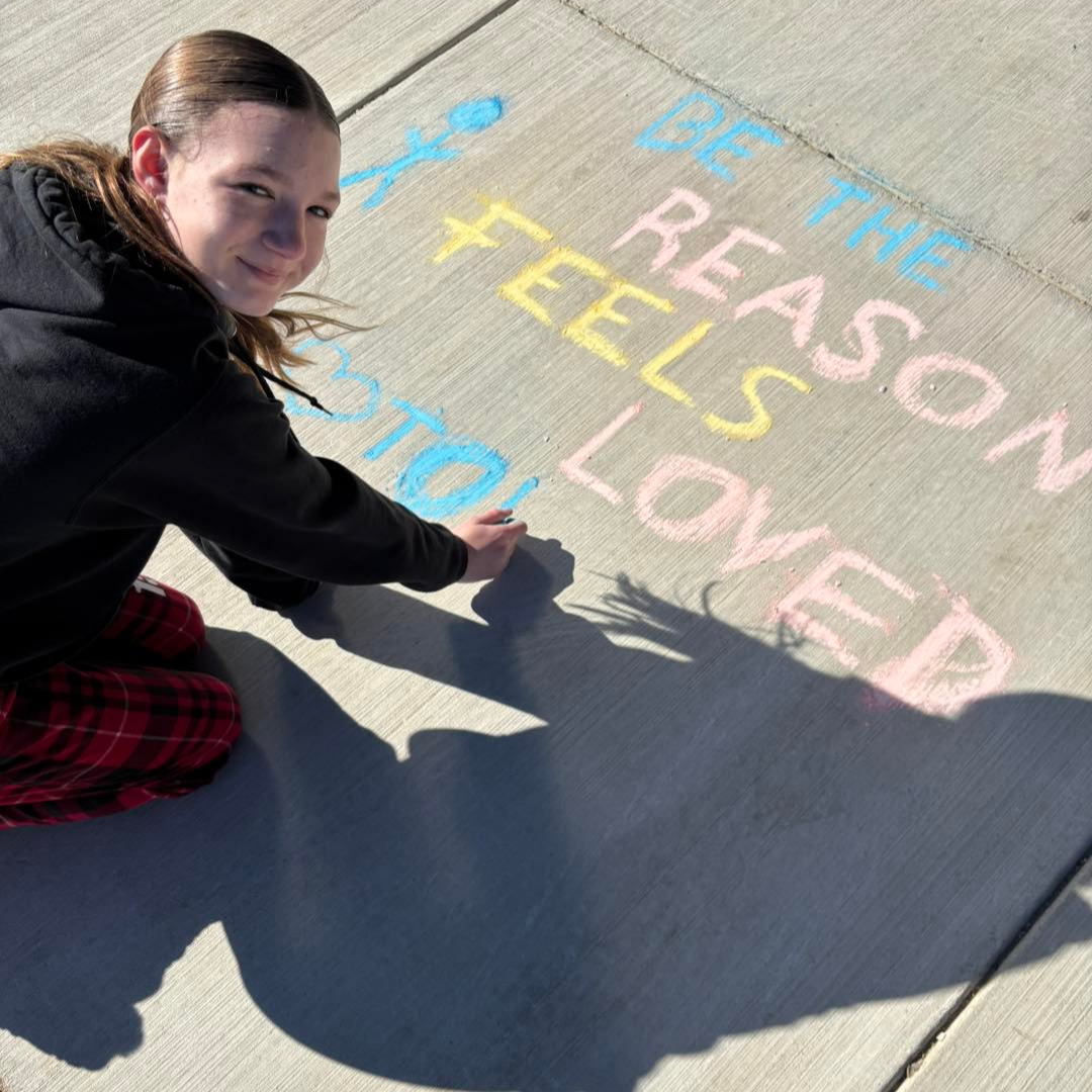 student with sidewalk chalk